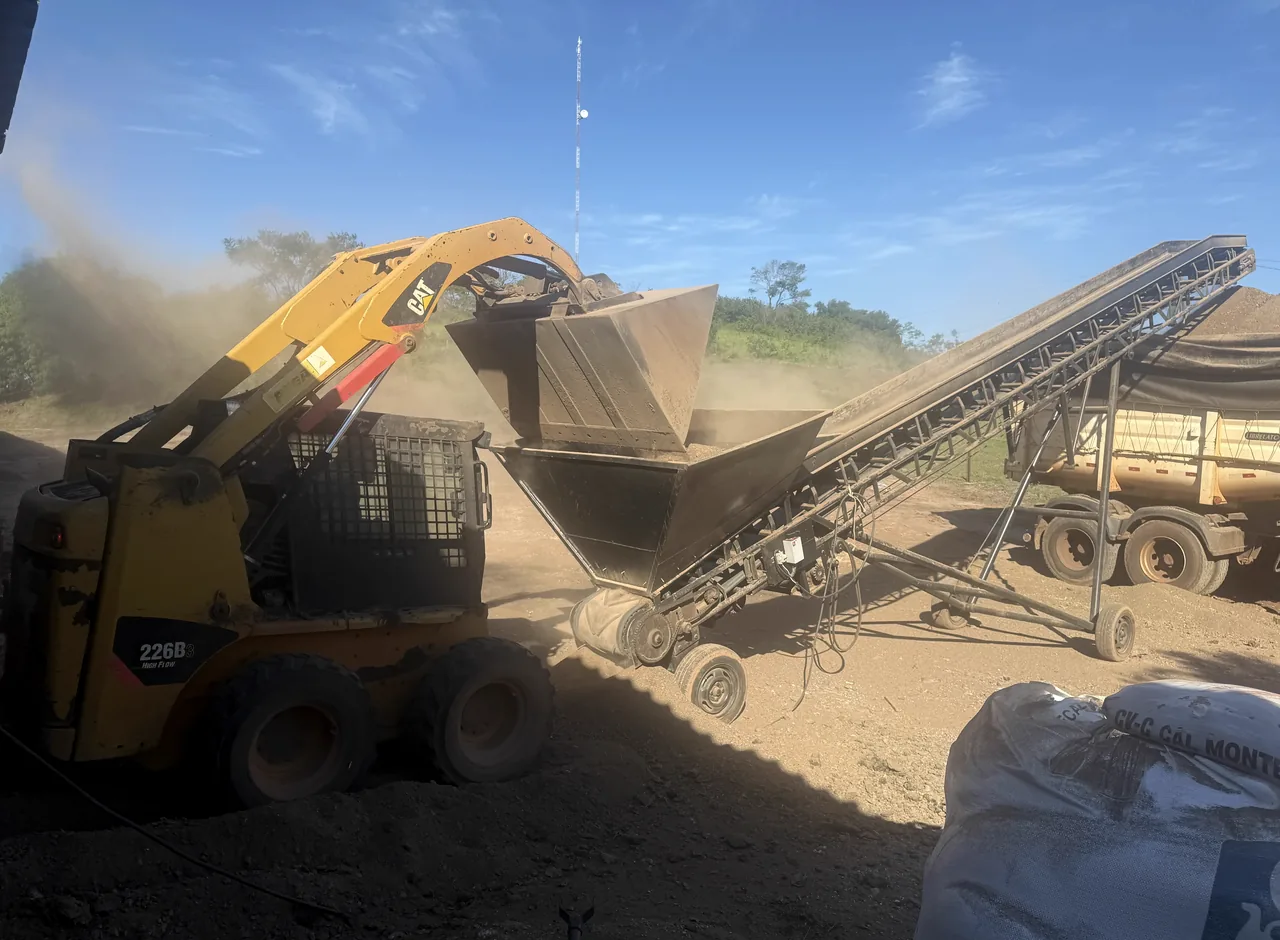 Máquina carregando material durante uma operação da Trindade Agro